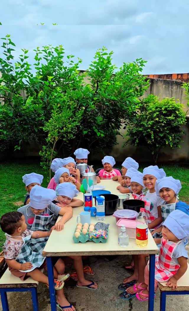 Crianças de touca de chef em atividade de culinária no Projeto Broto Novo